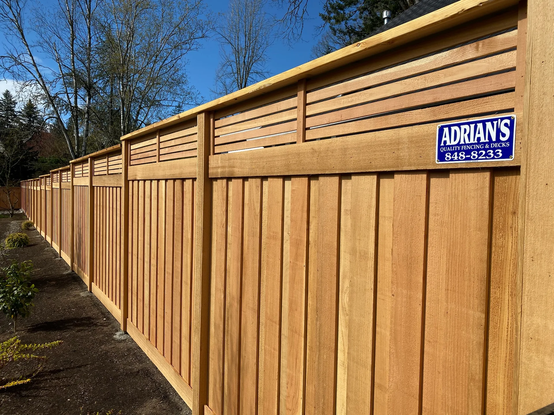 Finished cedar privacy fence with picture-frame panels and horizontal lattice
